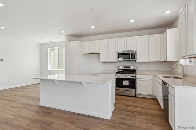 kitchen with stainless steel appliances, plenty of natural light, a sink, and a kitchen island