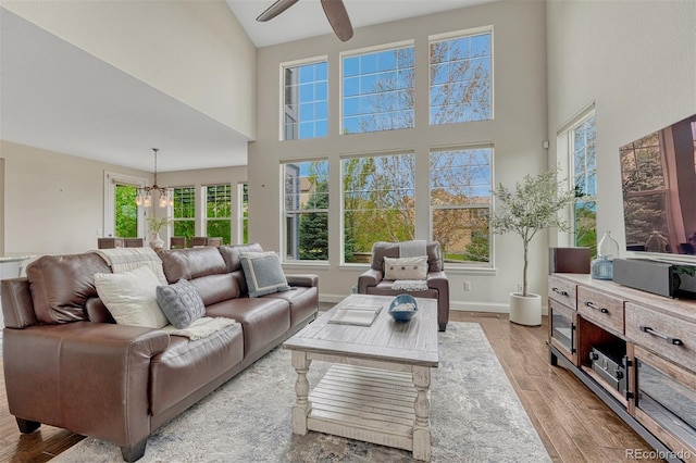 10365 Prairie Sky Pl, Lone Tree, CO 80124 - living room with a high ceiling, light wood finished floors, plenty of natural light, ceiling fan, and a chandelier