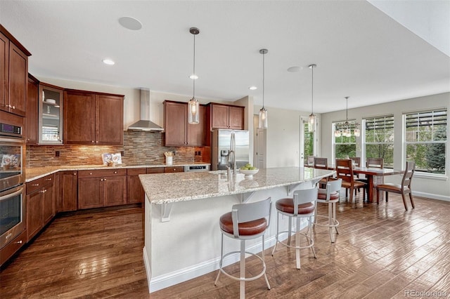 10365 Prairie Sky Pl, Lone Tree, CO 80124 - kitchen with wall chimney exhaust hood, stainless steel appliances, dark wood-type flooring, hanging light fixtures, and recessed lighting