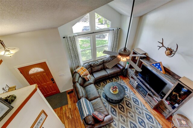 8555 Angela Ln, Parker, CO 80134 - living room featuring a textured ceiling, wood finished floors, lofted ceiling, and a ceiling fan