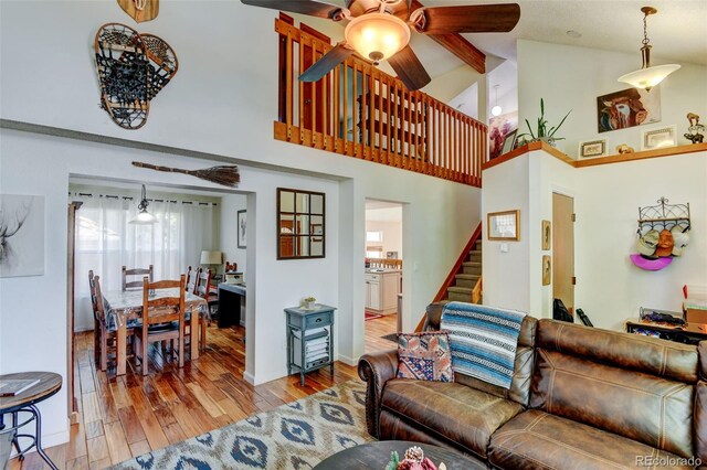 8555 Angela Ln, Parker, CO 80134 - living room with a ceiling fan, wood finished floors, stairway, high vaulted ceiling, and beam ceiling