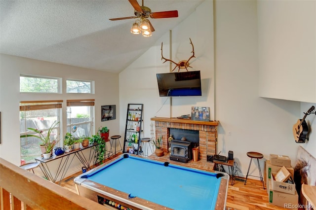 8555 Angela Ln, Parker, CO 80134 - playroom with a wood stove, wood finished floors, high vaulted ceiling, a ceiling fan, and a textured ceiling