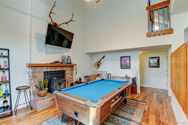8555 Angela Ln, Parker, CO 80134 - playroom with a towering ceiling, wood finished floors, a wood stove, billiards table, and baseboards
