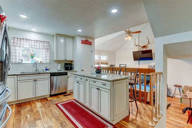 8555 Angela Ln, Parker, CO 80134 - kitchen with appliances with stainless steel finishes, a sink, light wood-style flooring, decorative backsplash, and ceiling fan