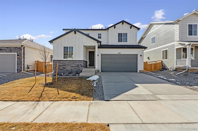 view of front facade with a garage, fence, driveway, stone siding, and board and batten siding