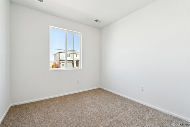 unfurnished room featuring visible vents, baseboards, and carpet