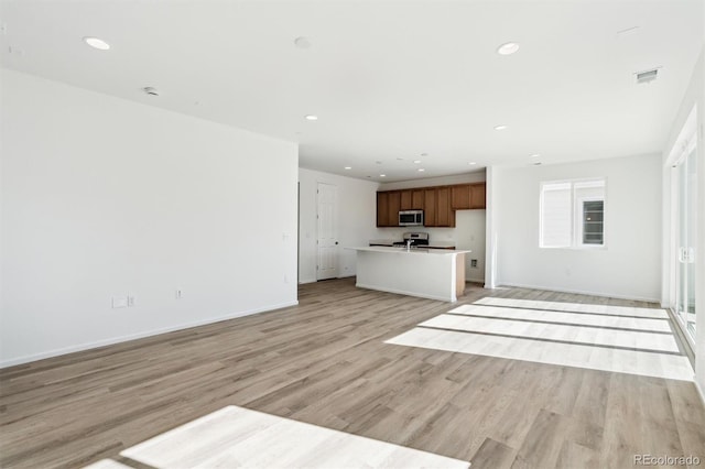 unfurnished living room featuring recessed lighting, visible vents, light wood finished floors, and baseboards