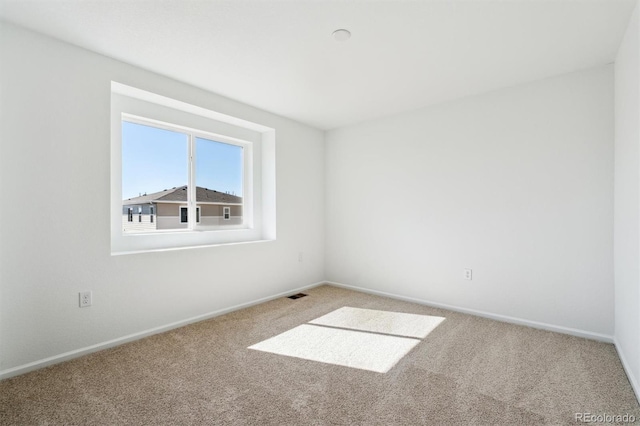 spare room with visible vents, baseboards, and carpet floors