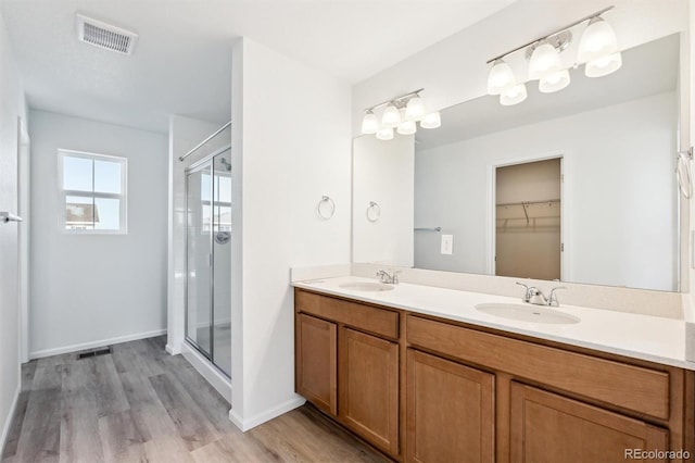 full bathroom with a sink, visible vents, a stall shower, and double vanity