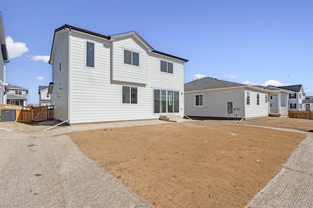 back of property with cooling unit and fence