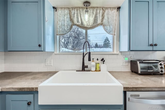 kitchen featuring blue cabinetry, sink, tasteful backsplash, dishwasher, and pendant lighting