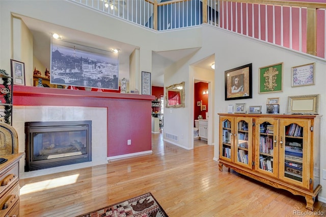 9172 Sunningdale Rd, Peyton, CO 80831 - living room featuring a high ceiling, a fireplace, baseboards, wood finished floors, and visible vents