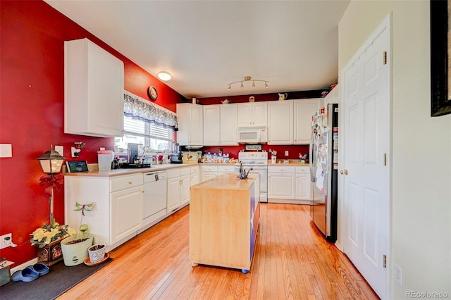 9172 Sunningdale Rd, Peyton, CO 80831 - kitchen with a kitchen island, light countertops, white cabinets, light wood finished floors, and white appliances