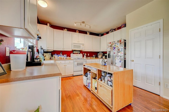 9172 Sunningdale Rd, Peyton, CO 80831 - kitchen with light wood finished floors, white appliances, light countertops, white cabinetry, and a kitchen island