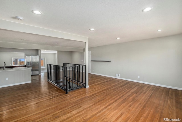 3092 S Kearney St, Denver, CO 80222 - empty room featuring a sink, wood finished floors, recessed lighting, baseboards, and a smoke detector
