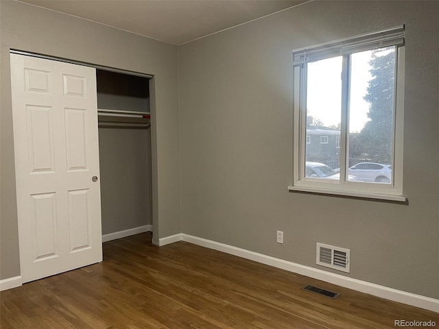 3092 S Kearney St, Denver, CO 80222 - unfurnished bedroom featuring dark wood-style floors, multiple windows, baseboards, and a closet