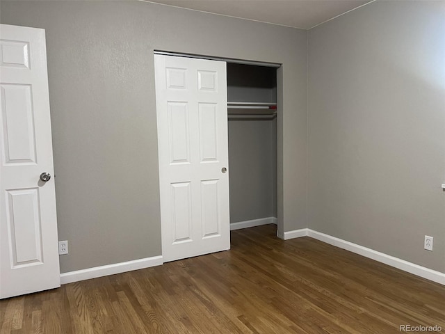 unfurnished bedroom featuring dark hardwood / wood-style flooring and a closet