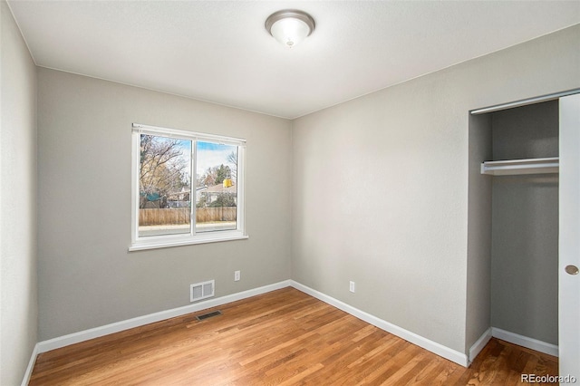 unfurnished bedroom with a closet and hardwood / wood-style flooring