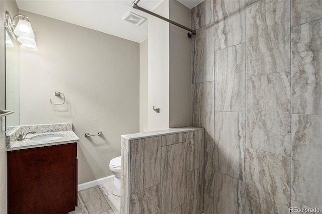 bathroom with a shower, vanity, and toilet