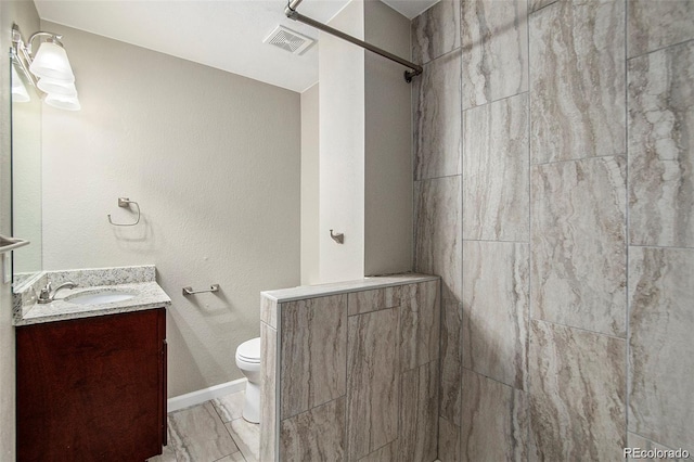 3092 S Kearney St, Denver, CO 80222 - bathroom featuring vanity, toilet, tiled shower, and marble finish flooring