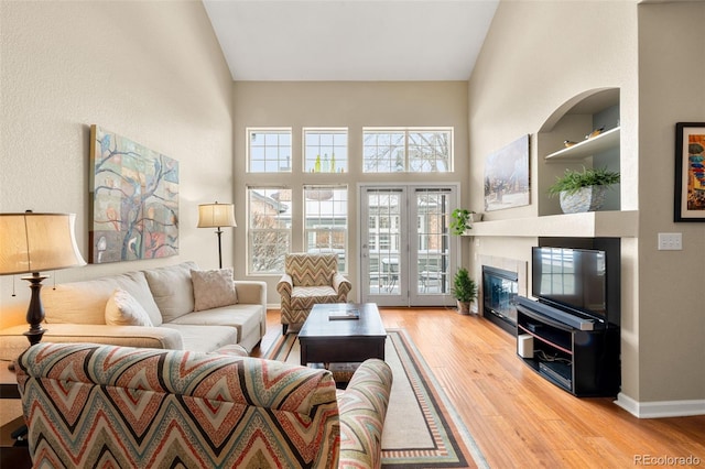 living room featuring a fireplace, a high ceiling, and hardwood / wood-style flooring