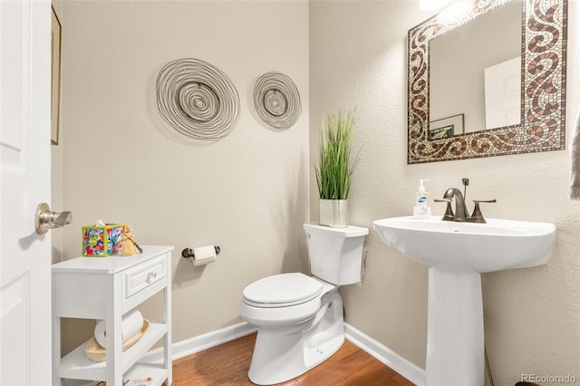 bathroom featuring sink, toilet, and hardwood / wood-style flooring