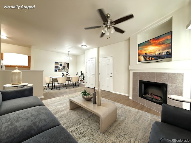 4451 S Ammons St Unit 108, Littleton, CO 80123 - living area featuring wood finished floors, a ceiling fan, and a tiled fireplace