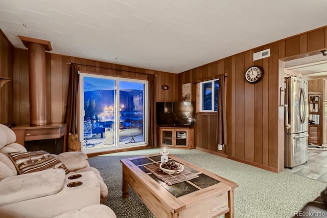 carpeted living room featuring wooden walls