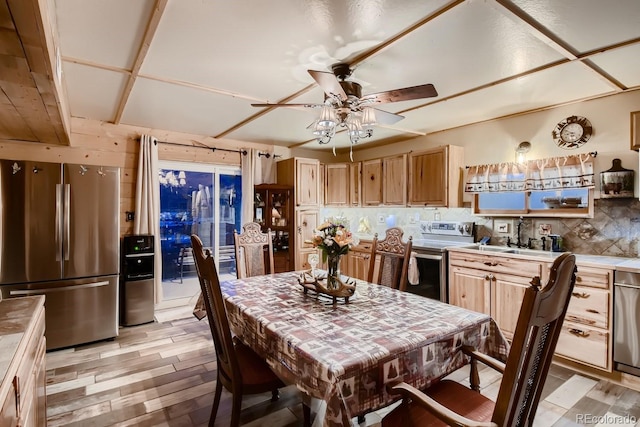 kitchen with sink, tasteful backsplash, light hardwood / wood-style flooring, ceiling fan, and stainless steel appliances