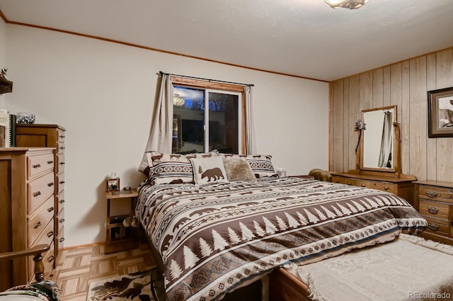 bedroom featuring ornamental molding, parquet floors, and wooden walls