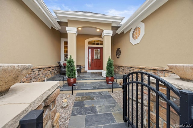 entrance to property featuring stone siding and stucco siding