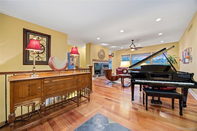 living area with visible vents, ceiling fan, recessed lighting, a fireplace, and wood finished floors