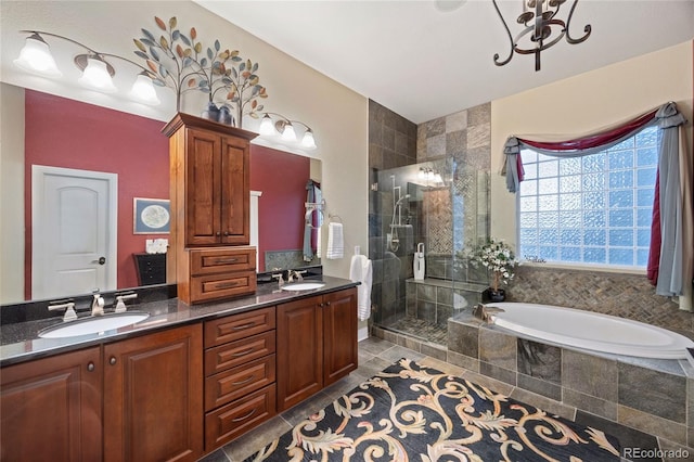 bathroom featuring a garden tub, double vanity, a stall shower, and a sink