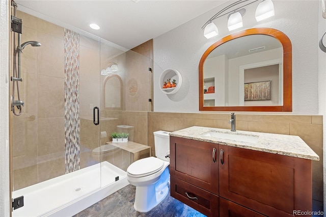 full bathroom featuring visible vents, toilet, a stall shower, tile walls, and vanity