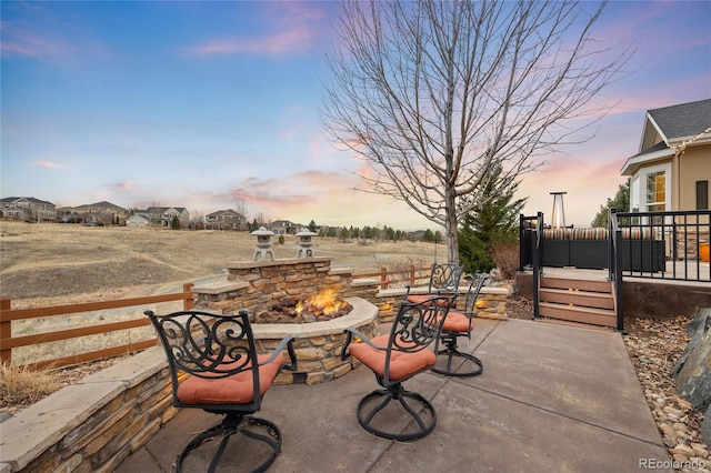 view of patio with a wooden deck, fence, and an outdoor fire pit