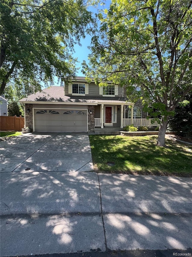 view of front of home with covered porch, a garage, and a front lawn