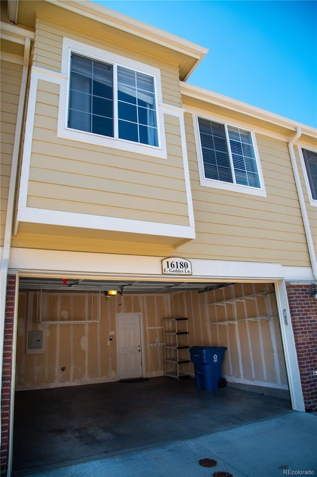 16180 E Geddes Ln Unit 14, Aurora, CO 80016 - view of property exterior featuring an attached garage, electric panel, and brick siding