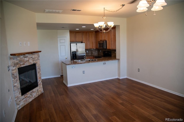 16180 E Geddes Ln Unit 14, Aurora, CO 80016 - kitchen featuring a chandelier, appliances with stainless steel finishes, dark wood finished floors, backsplash, and a peninsula