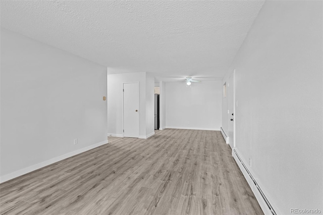unfurnished room featuring light wood finished floors, baseboard heating, ceiling fan, and a textured ceiling