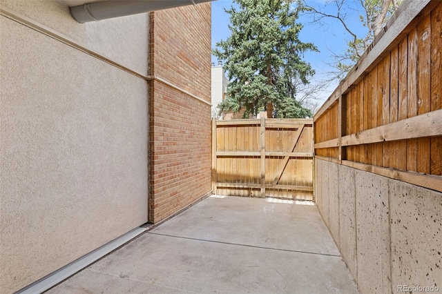 view of home's exterior with brick siding, fence, and a gate