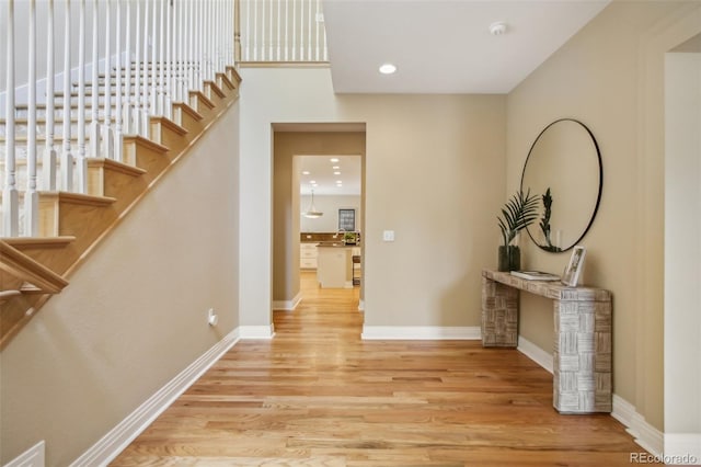 hall with stairs, recessed lighting, baseboards, and wood finished floors