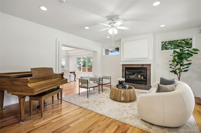 living area featuring wood finished floors, a tile fireplace, a ceiling fan, and recessed lighting