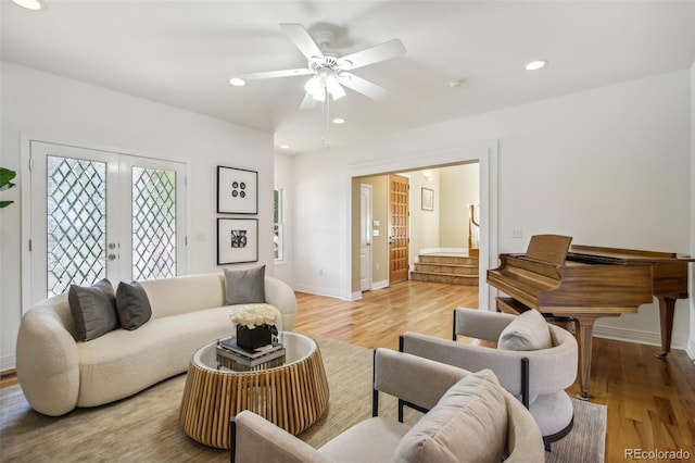 living room featuring french doors, recessed lighting, light wood-style floors, baseboards, and stairs