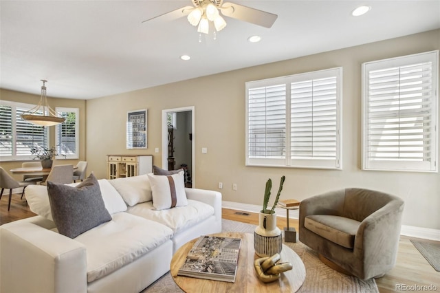 living area with baseboards, light wood finished floors, a ceiling fan, and recessed lighting