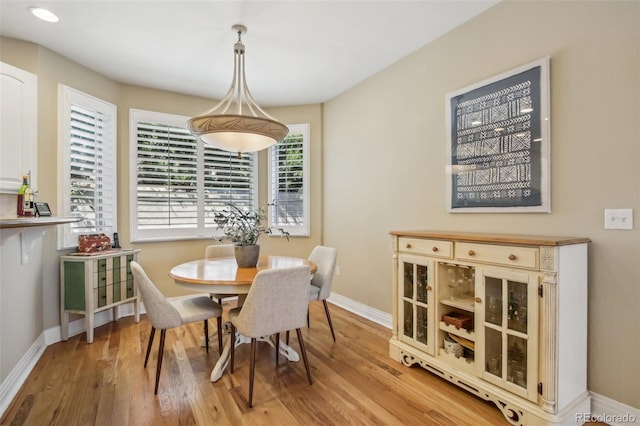 dining room with light wood-style floors and baseboards