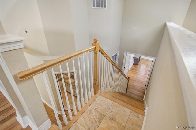 staircase with a towering ceiling and visible vents