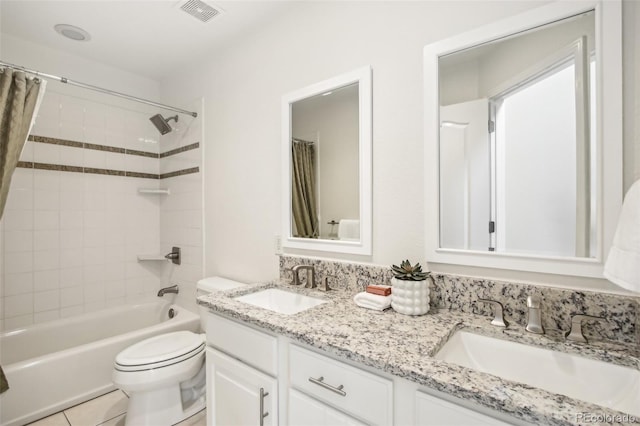 bathroom featuring toilet, double vanity, a sink, and visible vents