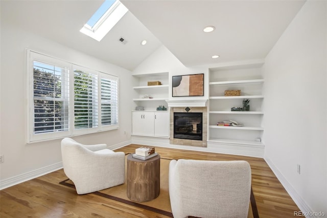 living room featuring a fireplace, light wood finished floors, and baseboards