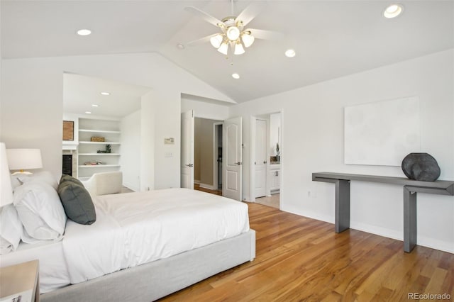 bedroom with a ceiling fan, ensuite bath, vaulted ceiling, light wood-style floors, and recessed lighting