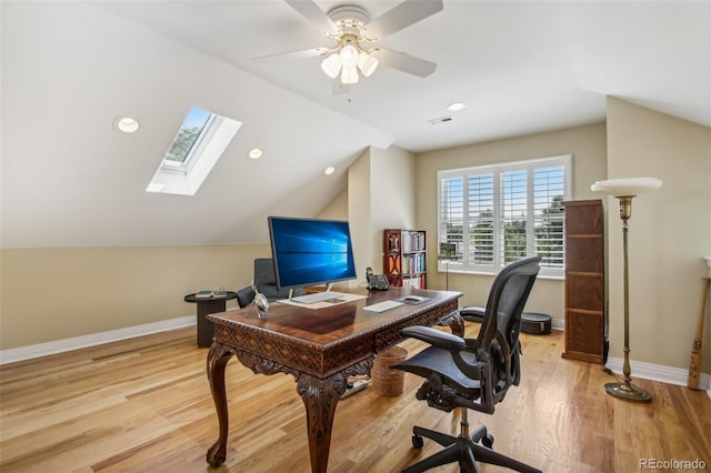 office with vaulted ceiling with skylight, baseboards, visible vents, and light wood finished floors